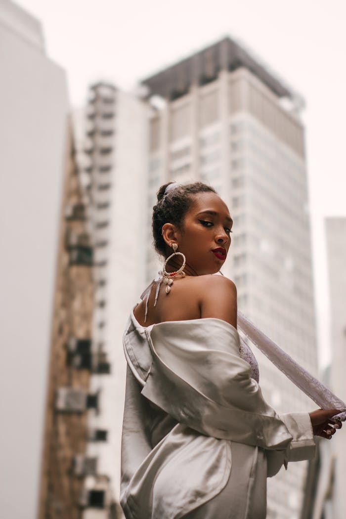 services-04 Stylish woman in a satin outfit posing confidently against a cityscape background.